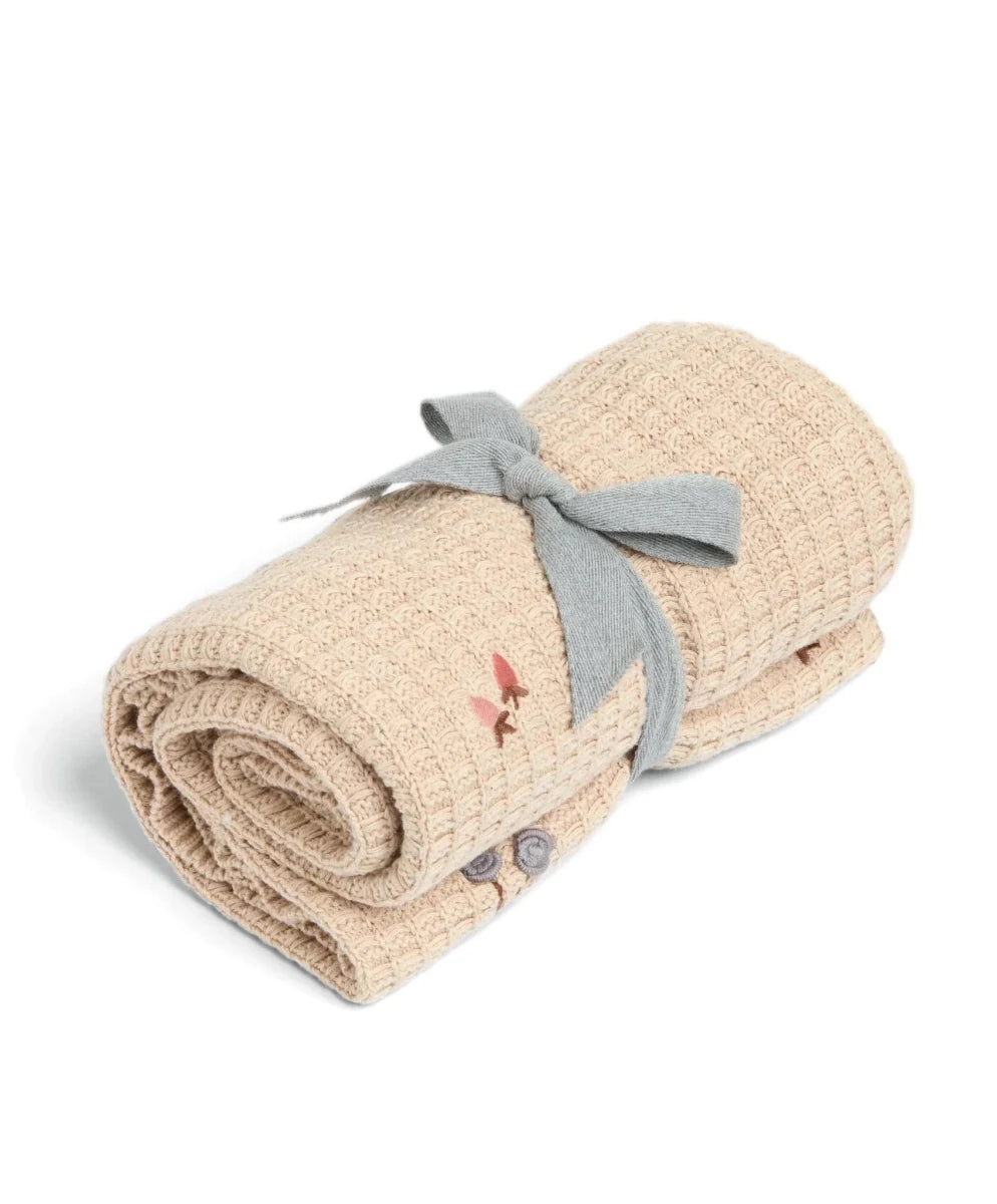 Cream knitted blanket rolled with bow tie and small multicolor motifs