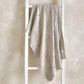 Light grey knitted blanket with scattered motifs, draped over frame.