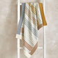 Knitted striped blanket with blue, cream, and rust stripes, ribbed border