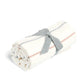Cream knit blanket roll with thin neutral stripes and gray tie ribbon