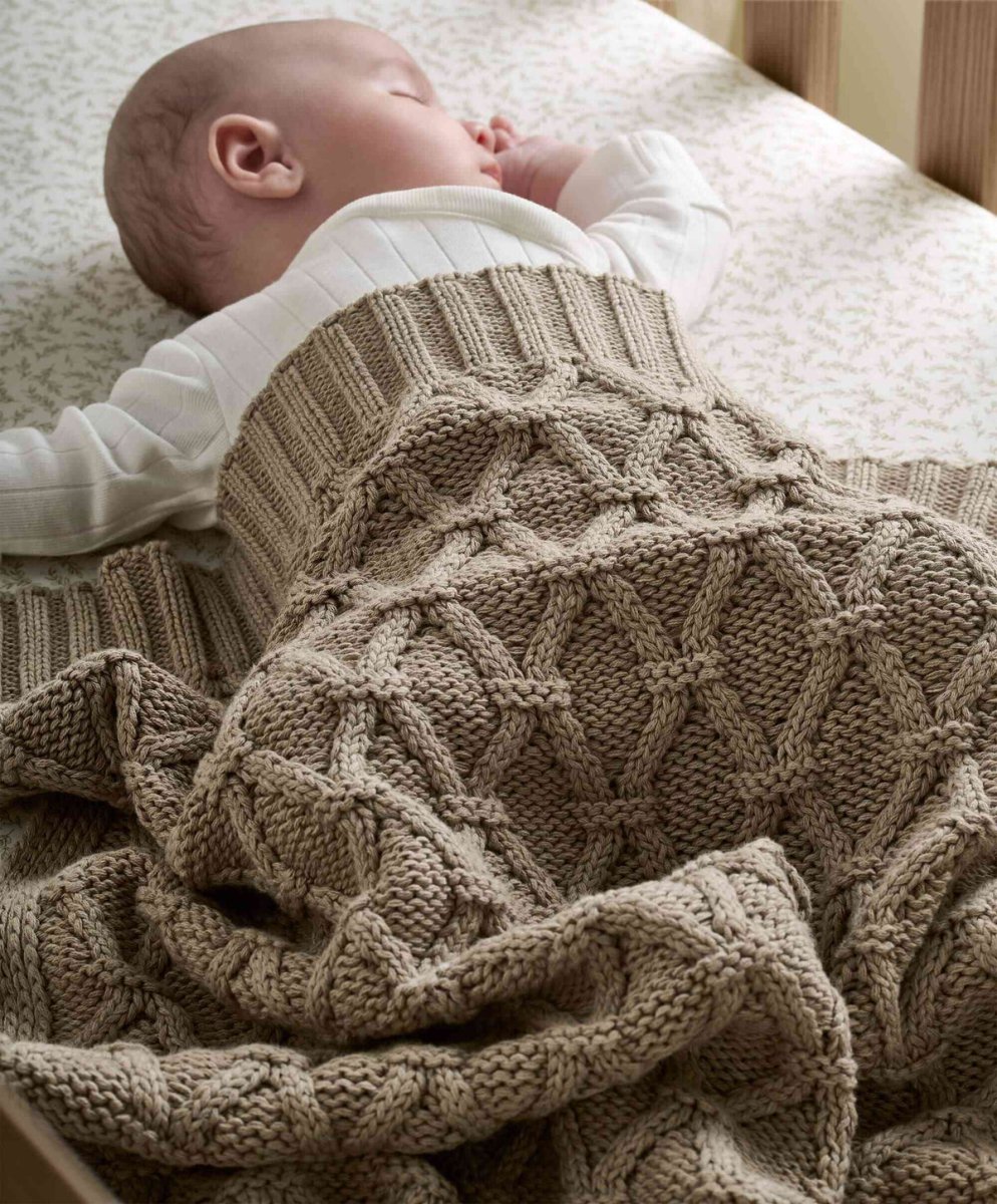 Knitted baby blanket in taupe, cable and textured knit wrap around infant