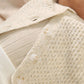 White knit cardigan close-up with textured stitch and button front
