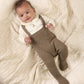 Cream teddy bodysuit with brown knitted dungarees, baby lying down