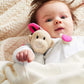Knitted hanging monkey toy, beige knit body with pink accents, held by baby
