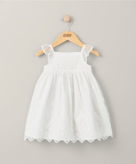 White lace baby dress with sleeveless bodice and scalloped lace hem