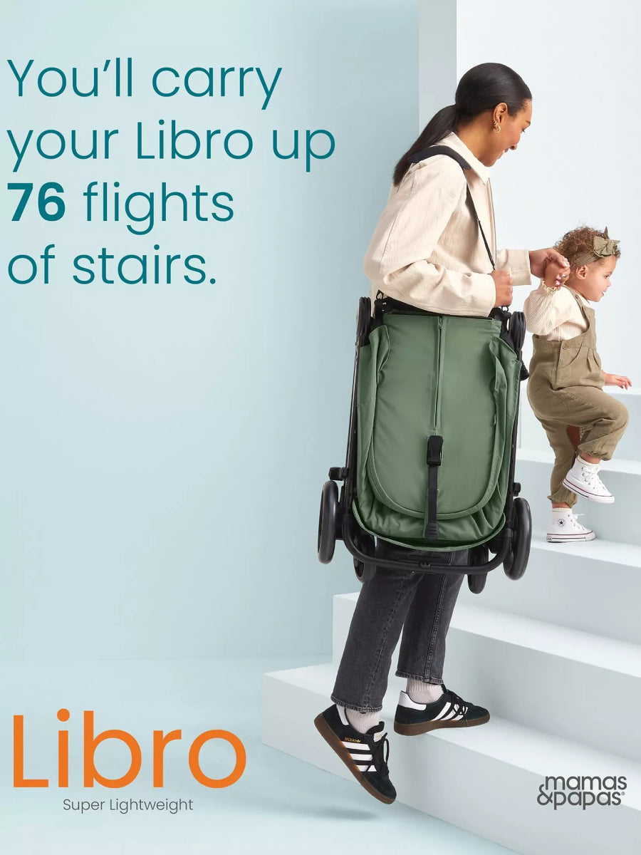 Green stroller carried up stairs, parent holding handle with toddler standing