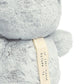 Light gray plush sensory owl with fabric tag and stitched foot detail
