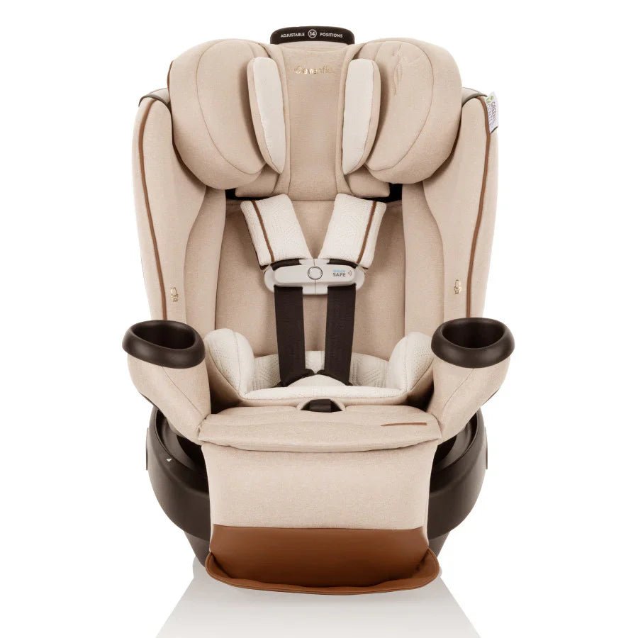 Champagne all-in-one car seat with quilted padding, harness buckle, and cup holders.