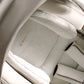 All-in-one car seat cushion in light champagne fabric, with evenflo logo patch.