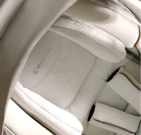 All-in-one car seat cushion in light champagne fabric, with evenflo logo patch.
