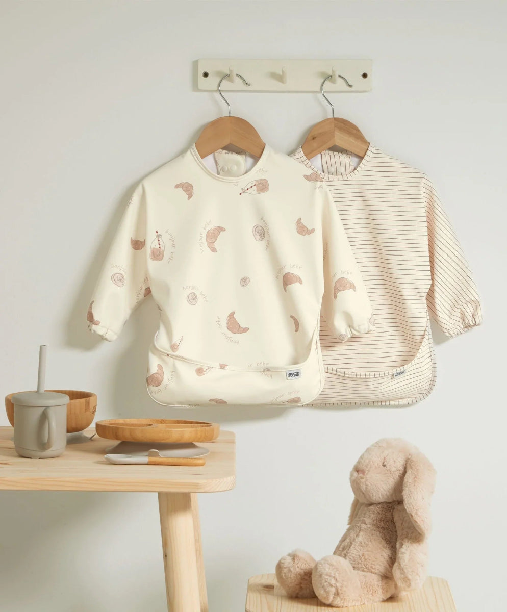 Two long-sleeve baby bibs: cream animal print and pale striped bib set.