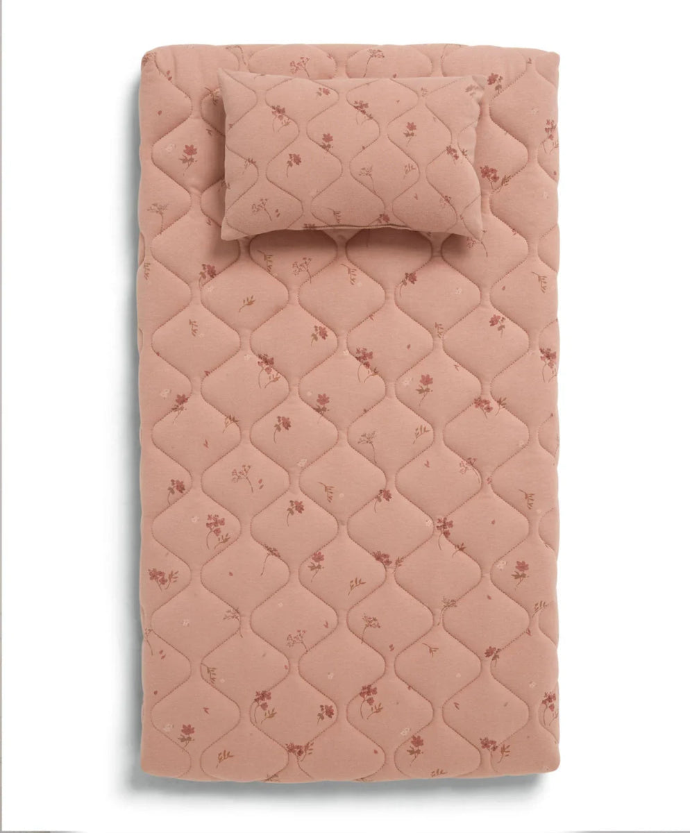 Blush pink quilted changing mat with small wildflower print and stitched border