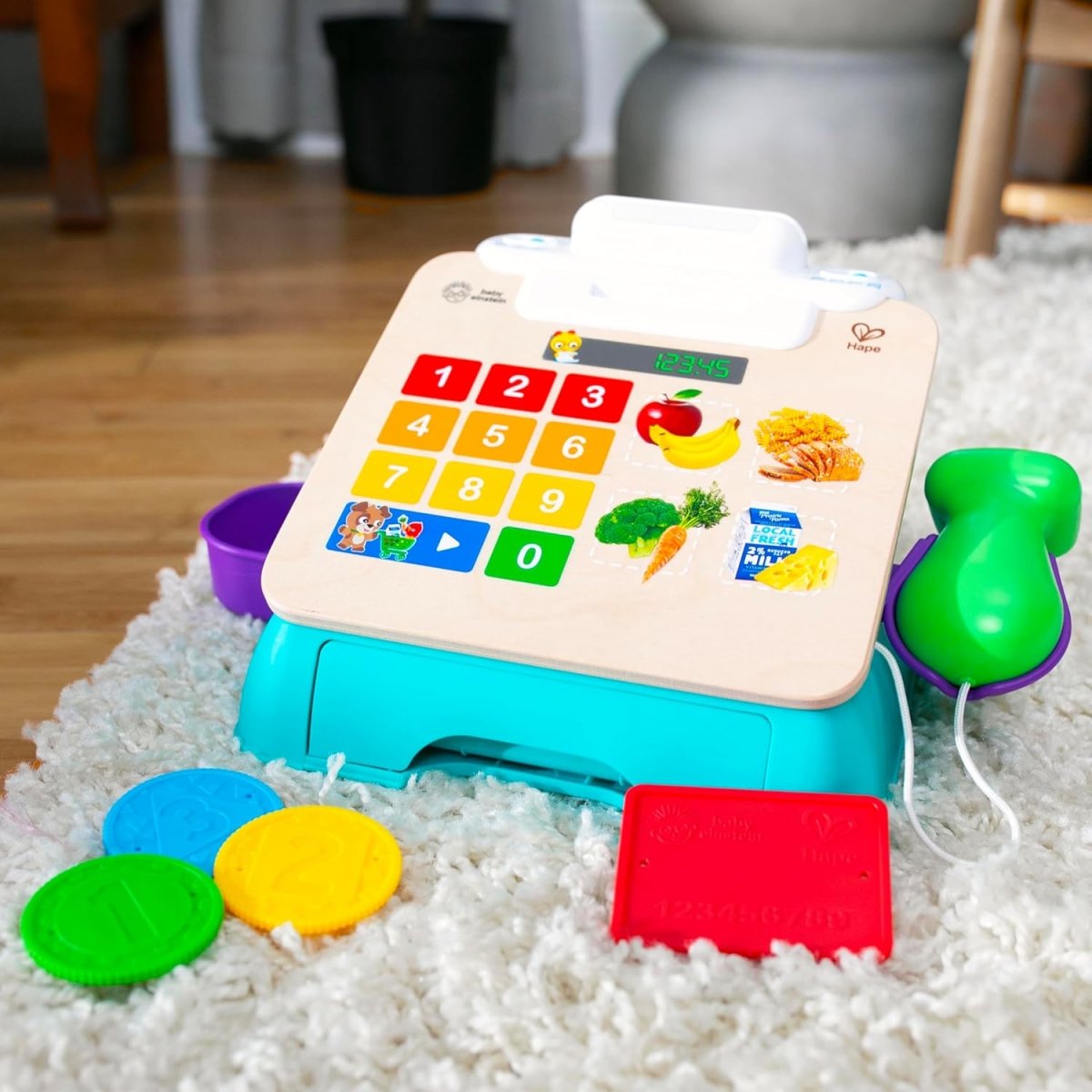 Blue toy cash register with number grid, fruit-themed keys, and colorful plastic cards