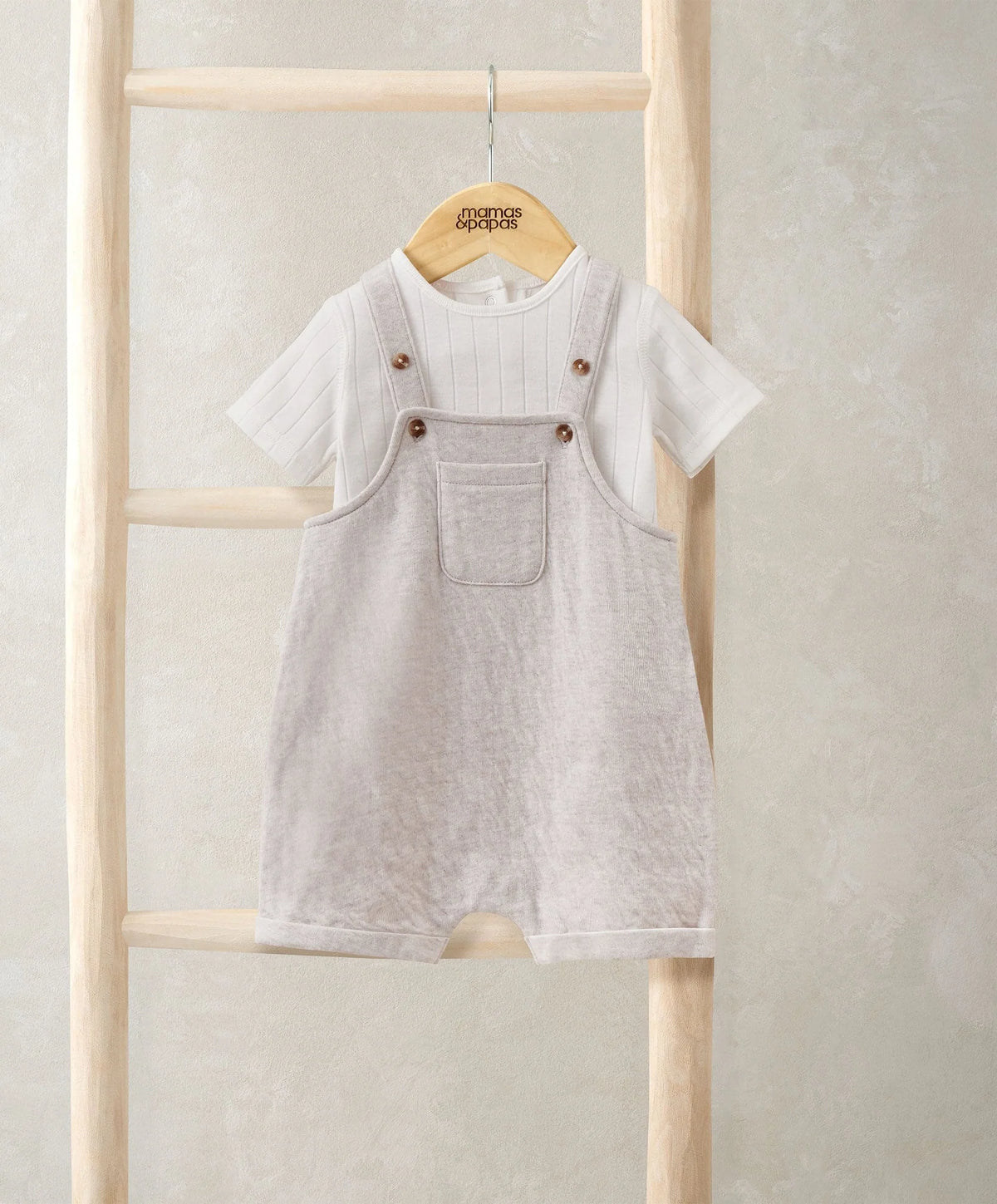 Grey short dungarees over white striped bodysuit, with front pockets and snap straps