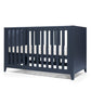 Midnight navy cotbed with vertical slats and open front, angled view