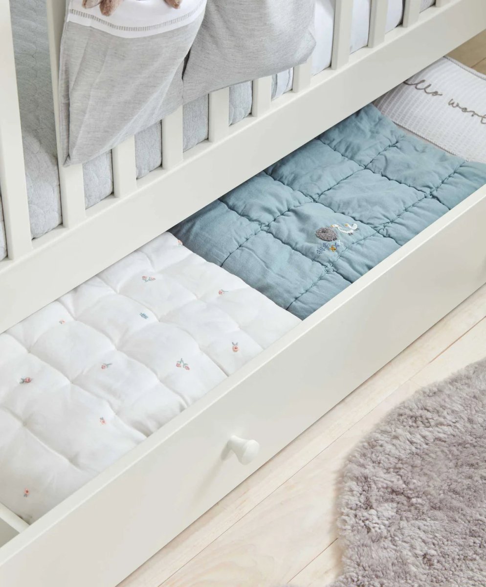 White Mia cotbed with white and light-blue patterned mattress pads