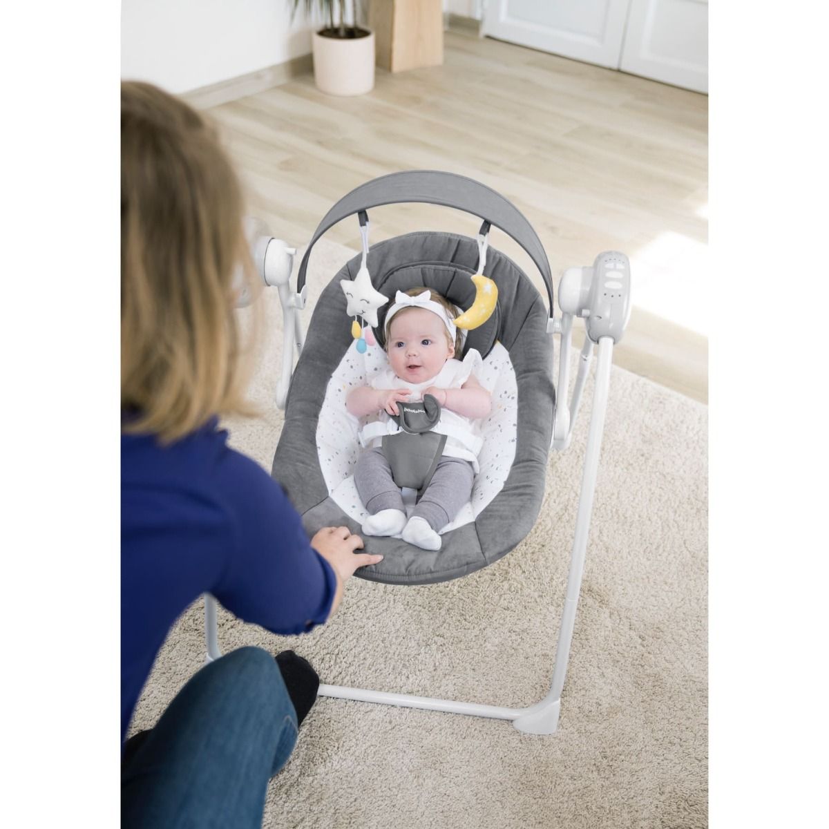 Infant swing with gray seat, toy bar, and five-point harness