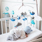 Baby music mobile with blue and gray plush animals and stars on crib