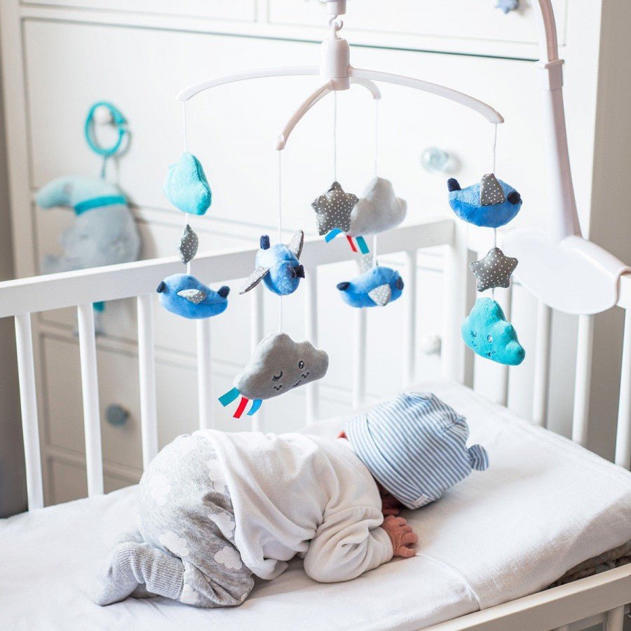 Baby music mobile with blue and gray plush animals and stars on crib