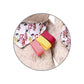 Close-up of plush rabbit keychain fabric ribbons in red, yellow, and striped print
