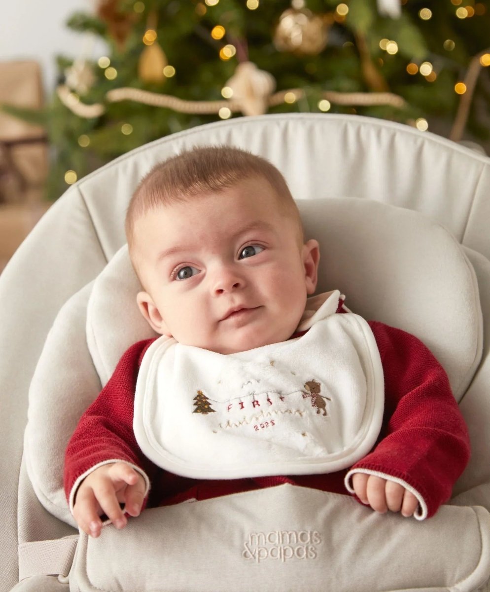 Baby Christmas bib on infant, white front with embroidered trees and reindeer