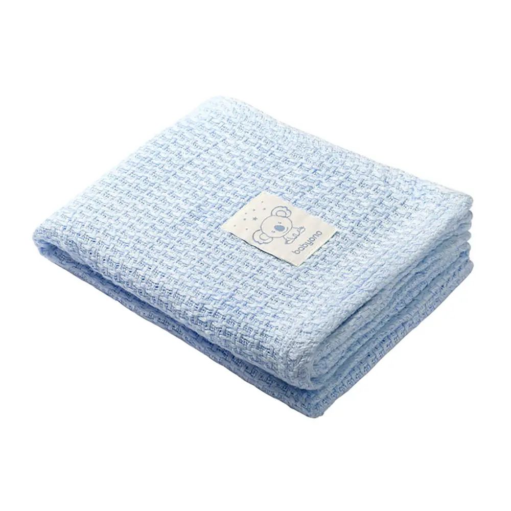 Light blue knitted bamboo blanket, folded with stitched label