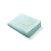 Mint green knitted bamboo blanket, folded with stitched care label