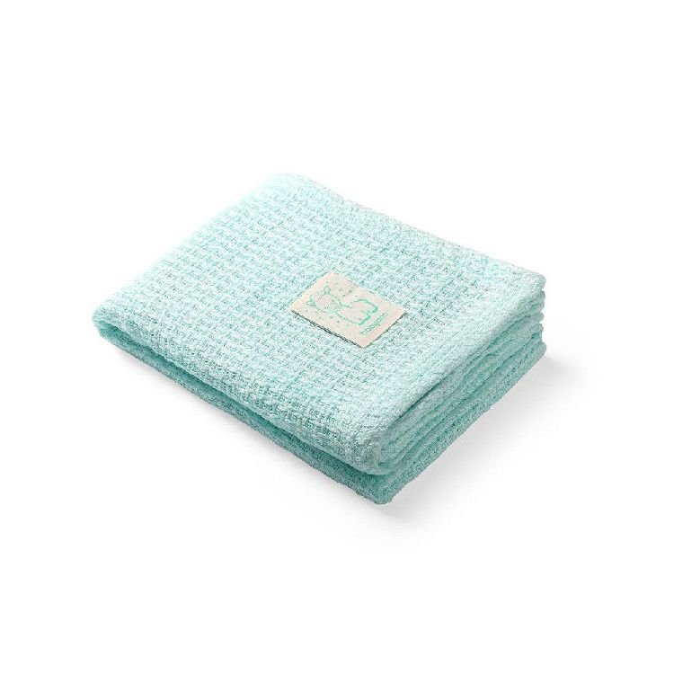 Mint green knitted bamboo blanket, folded with stitched care label