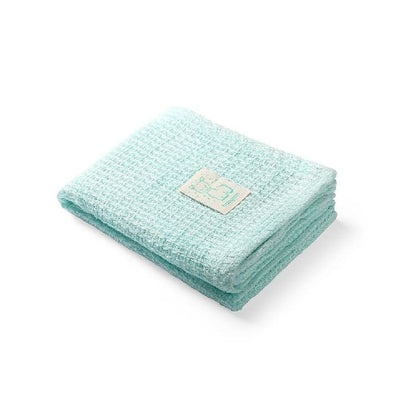 Mint green knitted bamboo blanket, folded with stitched care label