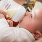 Baby drinking from a bottle with clear teat and soft white rim