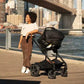 Black stroller with attached infant car seat, push handle and wheels visible.