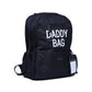 Nursery backpack back view, dark with 'DADDY BAG' lettering and hanging tag
