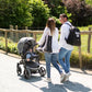 Nursery backpack worn by parent with dark 'DADDY BAG' print, paired with stroller