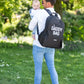 Nursery backpack on parent with 'DADDY BAG' print while holding baby