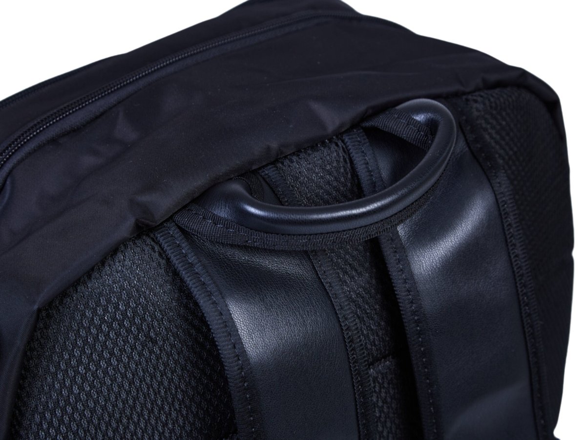 Nursery backpack side panel with carry handle and zippered front pocket on dark fabric