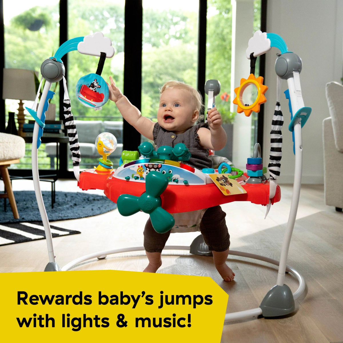 Baby activity jumper with red seat tray, blue arches, and hanging gear-shaped toy