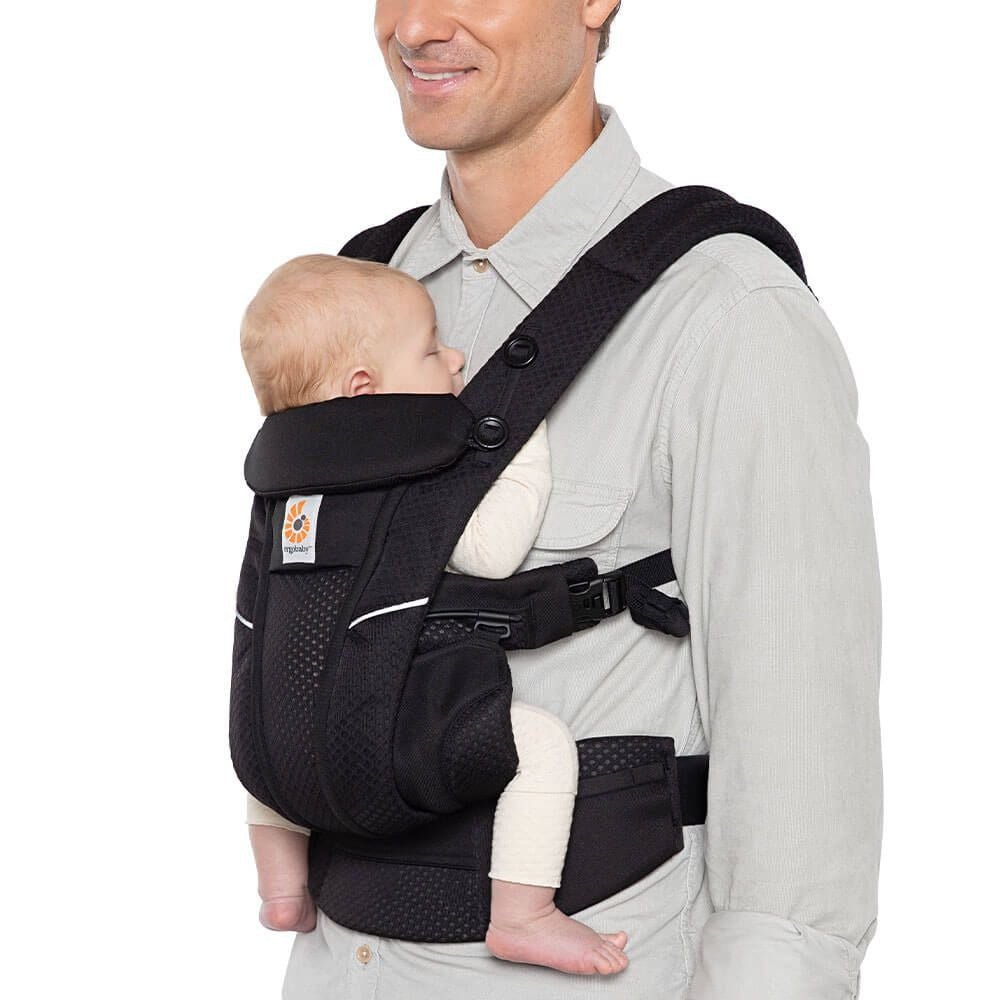 Onyx Black baby carrier with front wrap holding a newborn