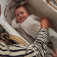 Oatmeal ribbed long-sleeve baby bodysuit on infant in a soft knit blanket