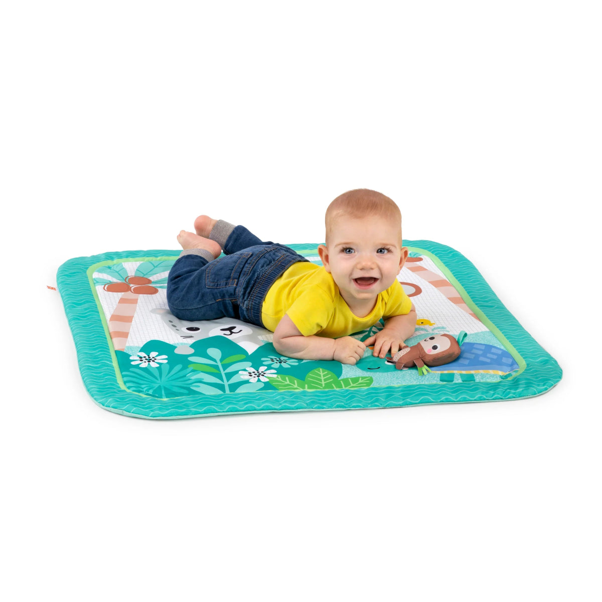 Baby crawling on jungle activity mat with small toy on top, teal border and leaf patterns