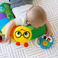 Green activity pillow for tummy time with yellow caterpillar face and blue mirror