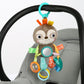 Plush animal take-along toy with teal handle loop and circular sensory ring detail.