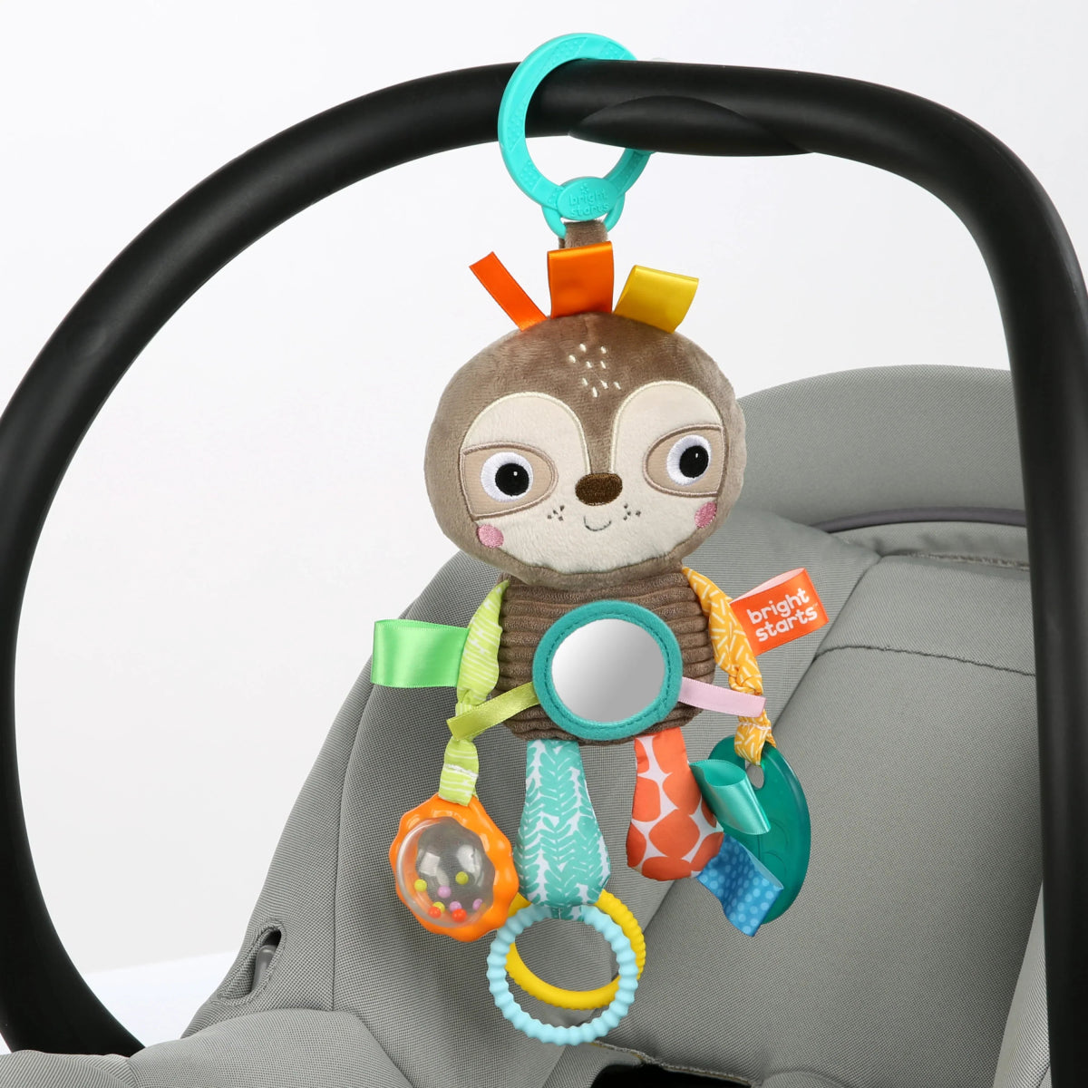Plush animal take-along toy with teal handle loop and circular sensory ring detail.