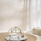 Round beige playmat with gray play arch and hanging cloud, star and moon toys