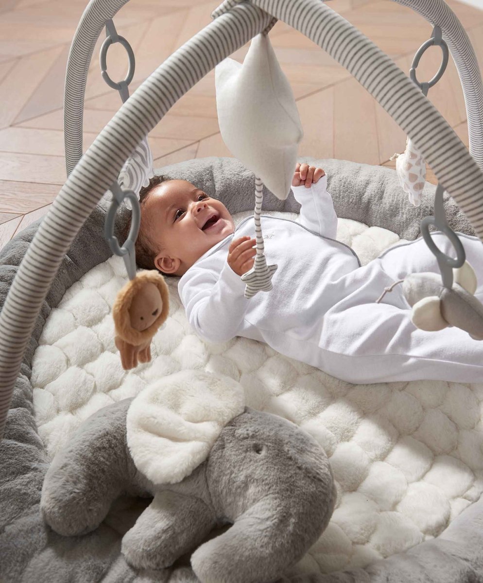 Elephant playmat gym with gray cushion and arch, hanging toys above baby at play