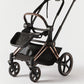 Stroller with black seat, dark tray, rose-gold frame accents, and front wheels