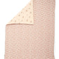 Floral quilt with pink reverse side and cream top panel, folded corner visible