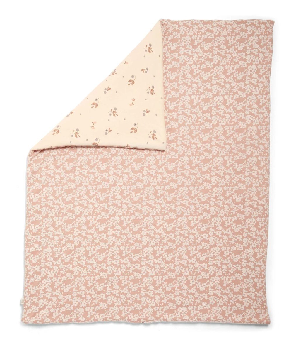 Floral quilt with pink reverse side and cream top panel, folded corner visible