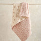 Floral quilt draped over hanger, cream side with small blossoms and pink reverse