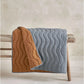 Wave quilt with light blue front and brown reverse, quilted wavy stitch and edge trim