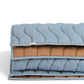 Stacked wave quilt layers: light blue top with brown lining and stitched wavy channels